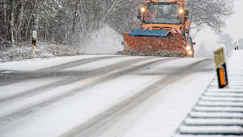 Ein Fahrzeug vom Winterdienst räumt den Schnee von einer Straße bei Hunderdorf (Kreis Straubing-Bogen).