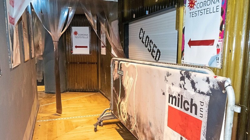 Teststation statt Disco: Im Eingangsbereich der Münchner "Milchbar" steht ein Absperrgitter. Hinweisschilder an der Wand zeigen den Weg zu einer im Club aufgebauten Corona-Teststation.