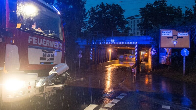 Ein Feuerwehrfahrzeug steht am 25.06.2016 in Straubing (Bayern) vor einer überfluteten Bahnunterführung. Schwere Gewitter und Starkregen sorgen in Bayern immer wieder für überflutete Straßen und vollgelaufene Keller.