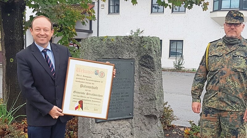 Bürgermeister Christian Hirtreiter (links) und Kompaniefeldwebel Oberstabsfeldwebel Jörg Luther mit der ersten gemeindlichen Patenschaftsurkunde einer Sanitätseinheit der Gäubodenkaserne aus dem Jahr 1997.
