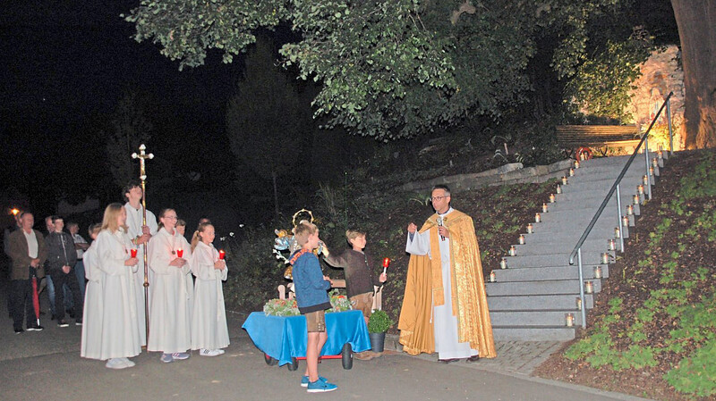Nach der Lichterprozession spendete Pfarrer Latacz den Gläubigen den Segen vor den mit Kerzenlichtern geschmückten Stufen der Mariengrotte.