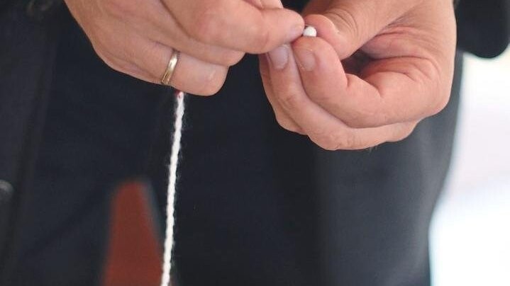 Perle für Perle wird mit Hilfe einer Nadel auf die Schnur gefädelt.