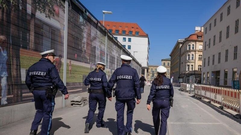 Vier Polizisten patroullieren durch eine fast leere Straße in der Innenstadt, hinter dem Rathaus. Foto: Peter Kneffel/dpa/Archivbild
