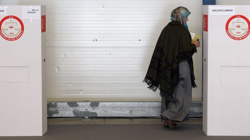 Eine türkische Frau geht in die Kabine eines Wahllokals in München.