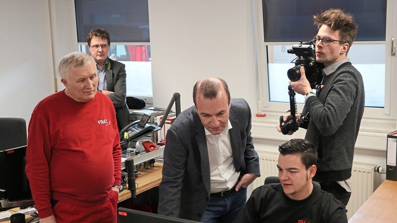 Manfred Weber schaut bei seinem Rundgang AMZ-Mitarbeiter Julian Obermeier über die Schulter, der eine Computersimulation zeigt; links Firmengründer und Geschäftsführer Andreas Martin.