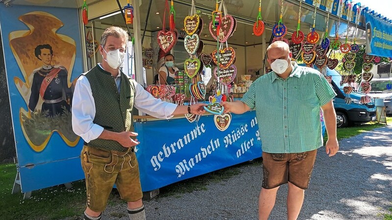 Bürgermeister Hans Schmalhofer (links) schenkt Thomas Schuster (rechts) ein Lebkuchenherz, weil er in Lederhosen und Trachtenhemd kam.