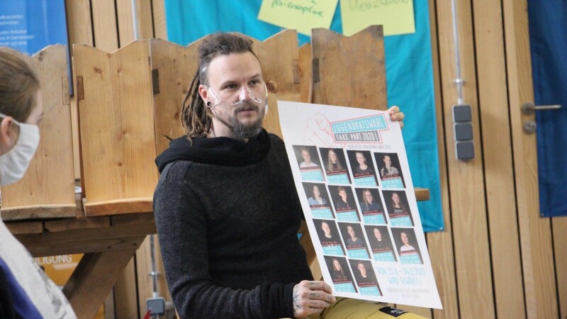 Marco Lorenz mit dem Plakat, das die Bewerber zeigt.