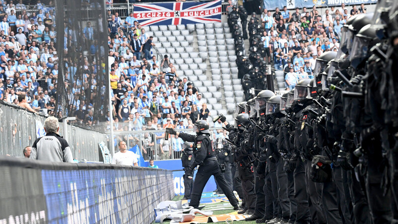 Kritische Situation: Polizisten und Ordner stehen den "Fans" gegenüber. Szene aus dem Relegationsspiel zwischen dem TSV 1860 München und Jahn Regensburg.
