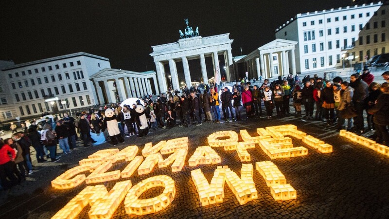 "Save our Climate! Now! (Rettet unser Klima! Jetzt!) steht 2015 in Berlin mit Kerzen dargestellt vor dem verdunkelten Brandenburger Tor.