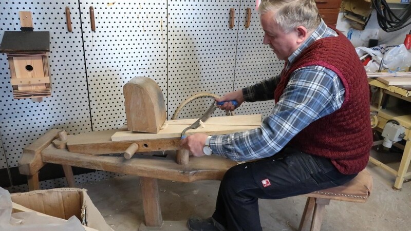 Anton Zollner spaltet das Holz so lange, bis es ganz dünn geworden ist. Dann bearbeitet er es mit einem Zugmesser.