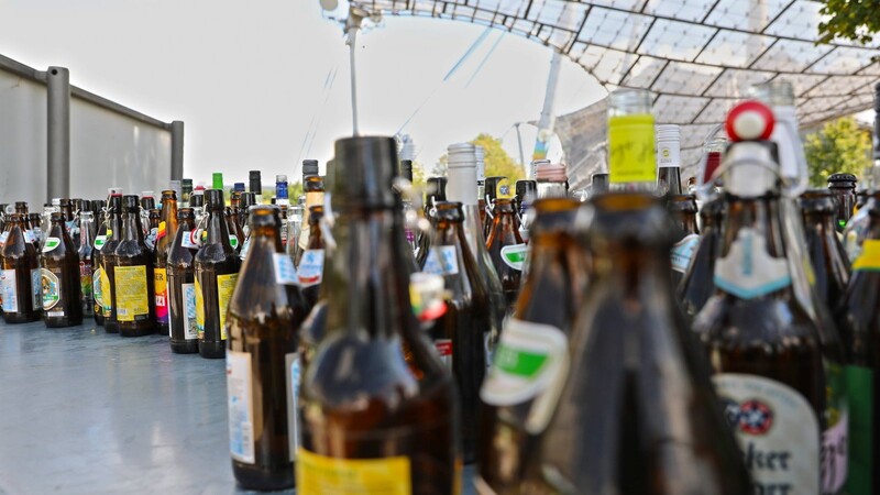Leere Bierflaschen stehen im Olympiapark. Brauer beklagen eine zu geringe Rückgabe von Leergut.