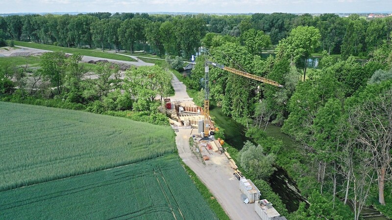 Noch bis Ende September werden die Bauarbeiten für die neue Brücke andauern. Später soll hier das rechtsseitige Ersatzfließgewässer in den Mühlbach münden. Der bisherige Isarauslass (Pfeil) kann dann komplett geschlossen werden.