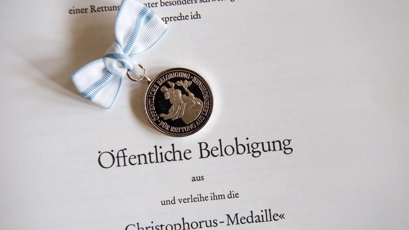 Die "Christophorus-Medaille" und die dazugehörigen Urkunde liegen am 24. Mai 2017 in München während der Verleihung der staatlichen Auszeichnungen für die Rettung von Menschen aus Lebensgefahr zusammen.