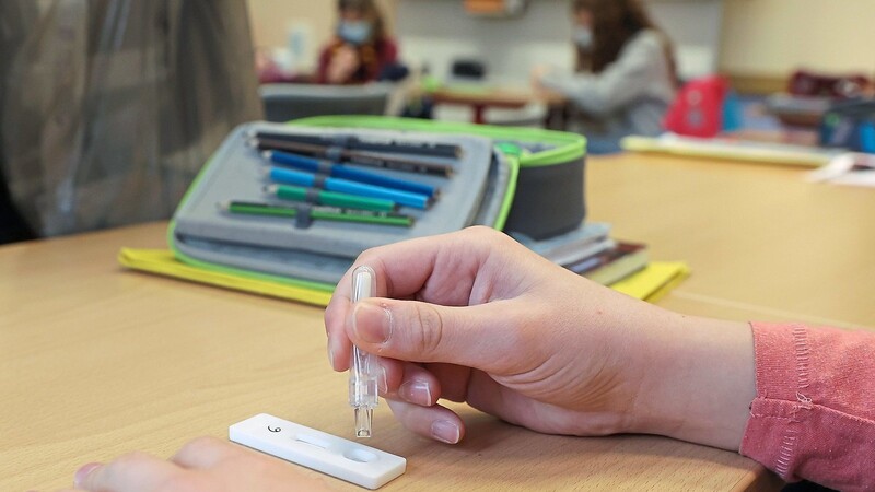 Eine Schülerin in Sachsen träufelt in einem Klassenraum eine Lösung nach einem selbst durchgeführten Corona-Test auf einen Sars-CoV-2-Antigentest. Auch in Bayern soll es nach den Ferien Selbsttests für Schüler und Lehrer geben.