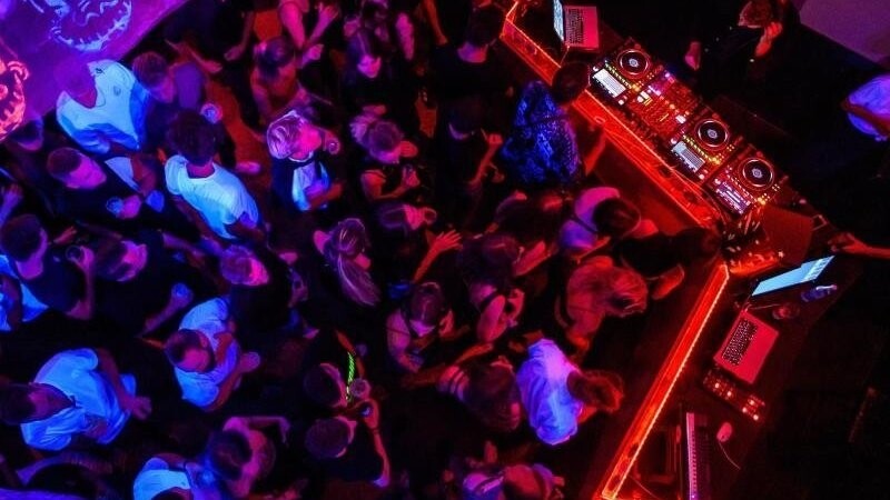 Das DJ-Kollektiv "ritual:digital" legt auf, während Clubbesucher auf der Tanzfläche tanzen.