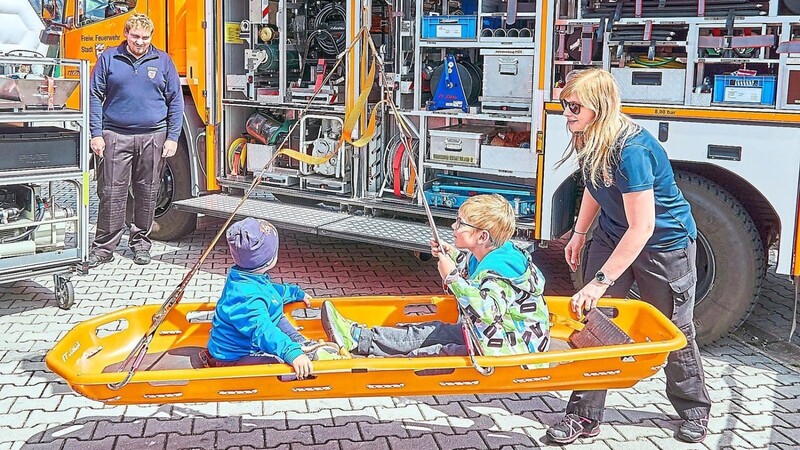 In der Rettungstrage des Rüstwagens der Chamer Feuerwehr dürfen die Kinder schaukeln.