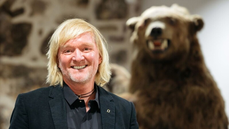 Andreas Kieling 2020 bei der Vernissage zu seiner Ausstellung "Mit den Grizzlys durch Alaska" neben einem Präparat eines Grizzlybären.