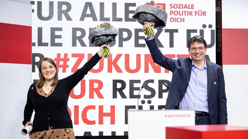 Ronja Endres, neu gewählte Landesvorsitzende der Bayern-SPD (l), und Florian von Brunn, neu gewählter Landesvorsitzender der Bayern-SPD, jubeln nach der Wahl von Endres und von Brunn als Doppelspitze für den Landesvorsitz auf einem digitalen Landesparteitag der Bayern-SPD in der SPD-Landesgeschäftsstelle mit Blumensträußen in den Händen.