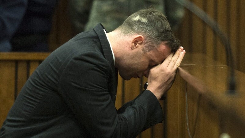 Oscar Pistorius bedeckt seine Augen, während Barry Steenkamp, Vater der getöteten Reeva Steenkamp, am zweiten Prozesstag aussagt.