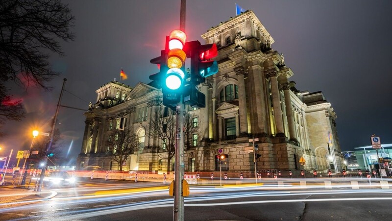 Eine Ampel leuchtet vor dem Reichstagsgebäude.