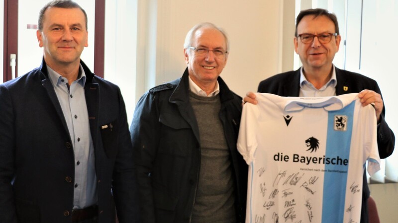 Manfred Paula, Leiter des Nachwuchsleistungszentrums beim TSV 1860 München (v.li.) und Löwen-Vizepräsident Hans Sitzberger überreichten Bürgermeister Franz Wittmann ein Trikot mit Unterschriften.
