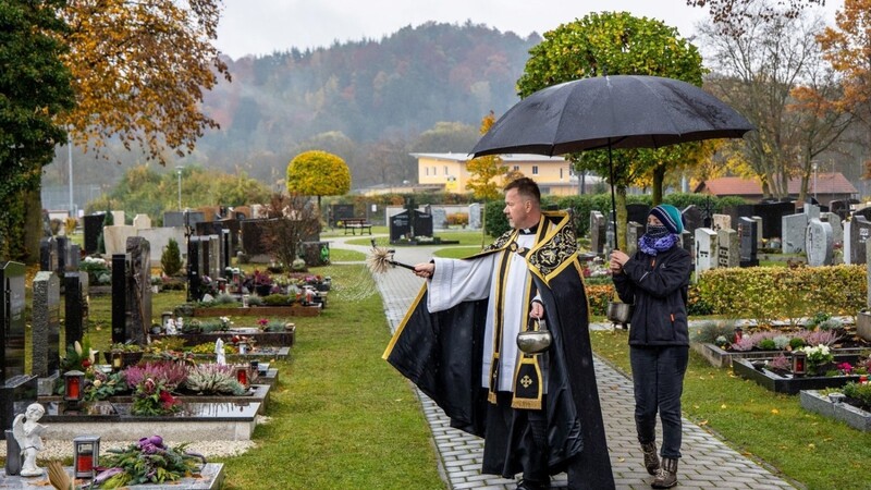 In Wörth machte sich Pfarrer Höllmüller auf den Weg durch die Grabreihen, um die letzten Ruhestätten zu segnen.
