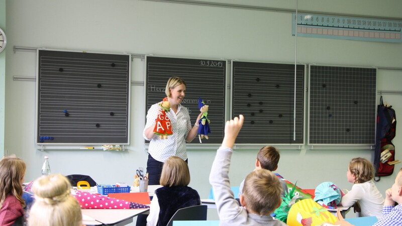 Grundschullehrerin Eva Kopp stellt den Kindern die Handpuppen Lola und Einstern vor.