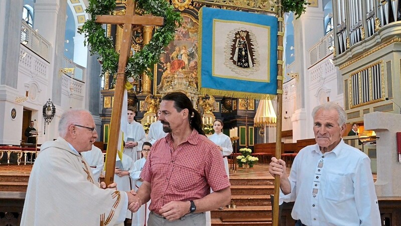 Pfarrer Dr. Kazimierz Pajor und Sepp Bucher übergeben Pilgerkreuz und Standarte an den neuen Pilgerleiter Christian Lommer.