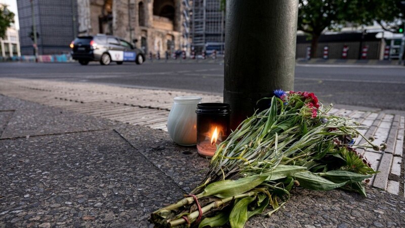 Kerzen und ein Blumenstrauß liegen zum Gedenken auf dem Bürgersteig an der Tauentzienstraße in Berlin.