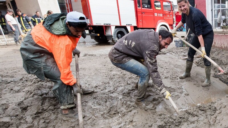 Freiwillige Helfer packen fleißig mit an, um den Schlamm von den Strassen zu räumen. Das verheerende Hochwasser in Niederbayern hat mindestens sechs Menschen in den Tod gerissen.