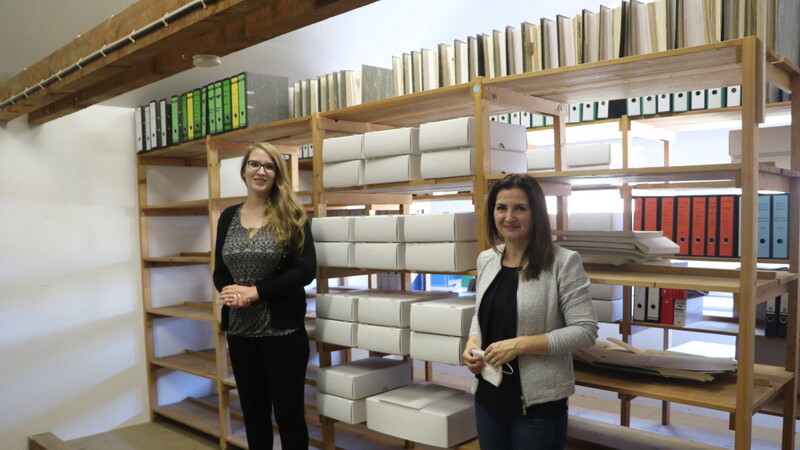 Anna Schmaußer (links) und Dr. Katja Putzer vor den Kisten, die die Unterlagen zum Ortsteil Wahlsdorf beinhalten. Die Dokumente werden entmetallisiert und in säuresicheren Mappen verwahrt. Die Kartons erhalten eine Signatur, damit die Unterlagen schnell aufgefunden werden können.