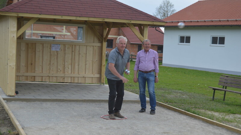 Gottfried Mitosch (rechts) zeigt zusammen mit dem Gemeinderatsmitglied Martin Freudenreich, wie man Boule auf der neuen Bahn spielt.