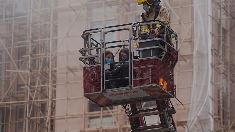 Zwei Frauen werden von einem Feuerwehrmann vom Dach des Hochhauses evakuiert. Nach Ausbruch eines Feuers sitzen mehr als 300 Menschen auf dem Dach des 38-stöckigen "Word Trade Centers" und warten auf Rettung.