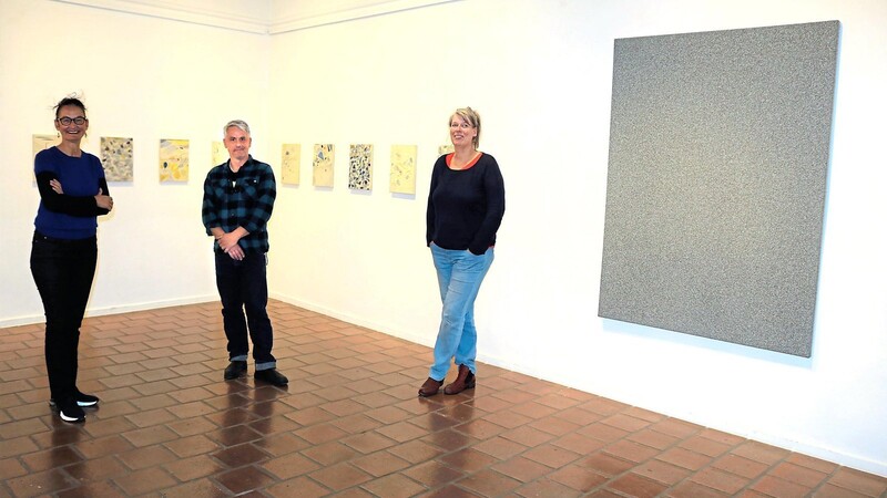 Galerieleiterin Anjalie Chaubal (links) mit zwei der Künstler: Rainer Neumeier und Almut Determeyer. Im Hintergrund zu sehen ist eine Bilderserie von Georg Fuchssteiner sowie ein Werk von Rainer Neumeier.