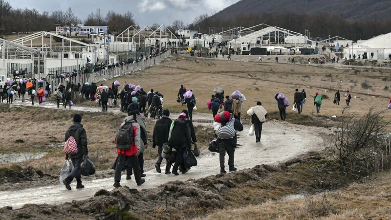 Migranten gehen mit ihren Habseligkeiten zurück zum Lager Lipa (Bosnien-Herzegowina) nahe Kroatien.