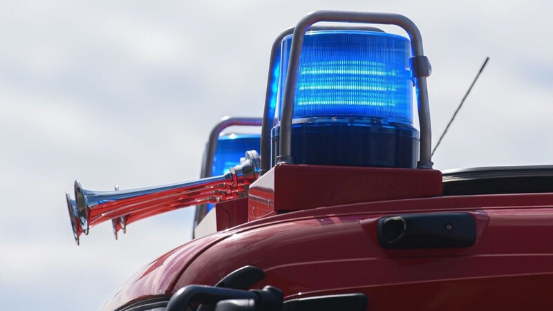 Blaulichter leuchten auf dem Dach eines Einsatzfahrzeugs der Feuerwehr.