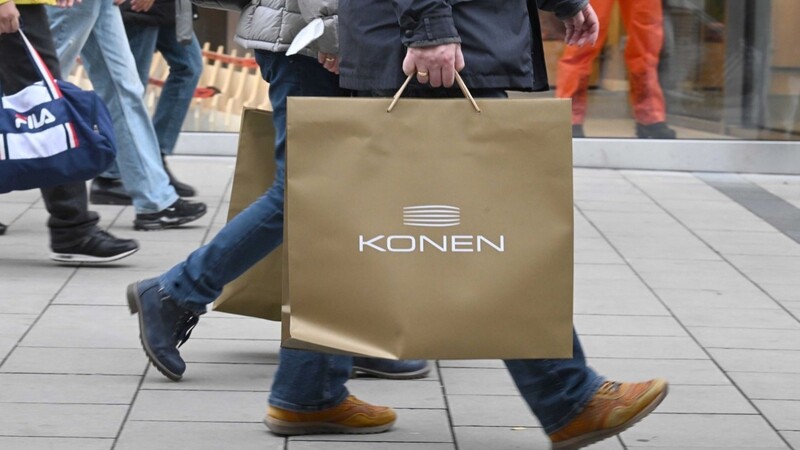 Ein Mann geht mit Einkaufstüten durch die Einkaufsmeile der Landeshauptstadt München.