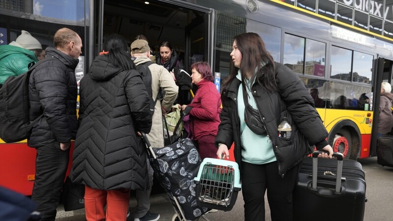 Geflüchtete aus der Ukraine steigen am Hauptbahnhof in Warschau in einen Bus ein.