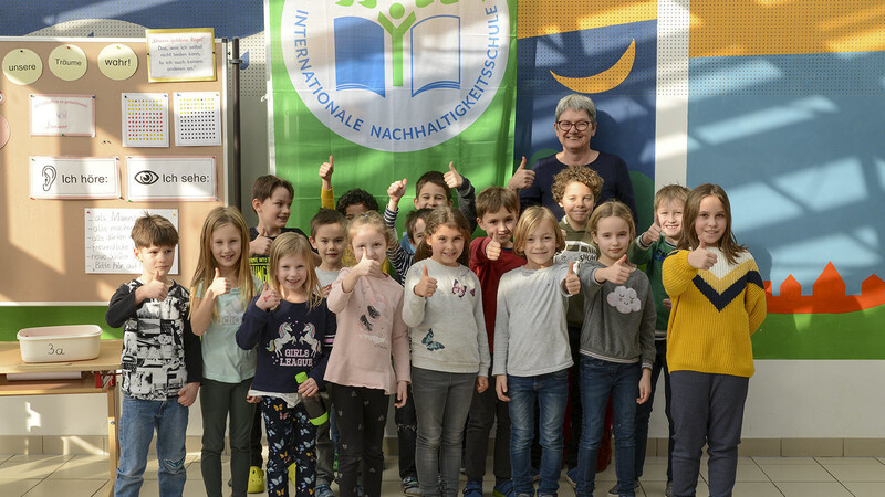 Die Fahne des LBV hängt als Auszeichnung für ein Jahr in der Aula. Die Grundschüler (mit Schulleiterin Friederike Elbauer) sind stolz auf ihre Projekte und auf die Auszeichnung.