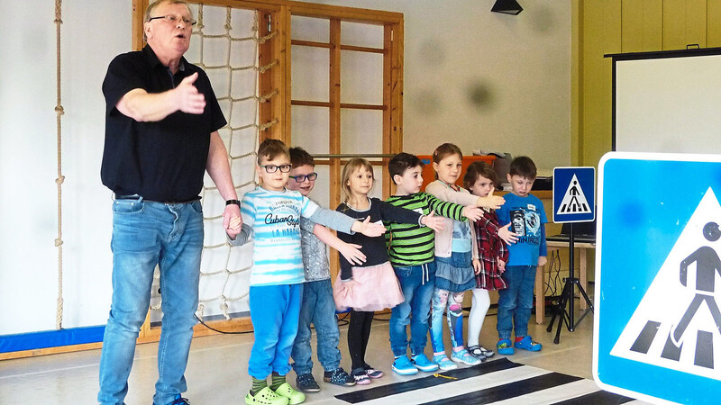 Geschäftsführer Peter Zehentmeier erklärt diesen Kindern das richtige Verhalten beim Überqueren eines Zebrastreifens. Das Bild entstand natürlich in Vor-Corona-Zeiten.
