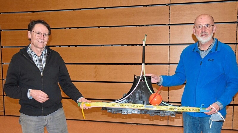 Bürgermeister Hans Sailer (links) und der Corwese-Experte Michael Räbinger präsentieren ein Modell für den Abzweig eines Hausanschlusses mit Glasfaser.