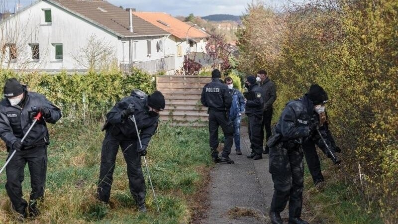 Eine Einheit der Bereitschaftspolizei durchsucht das Gelände um den Tatort in Bad Neustadt nach Spuren.