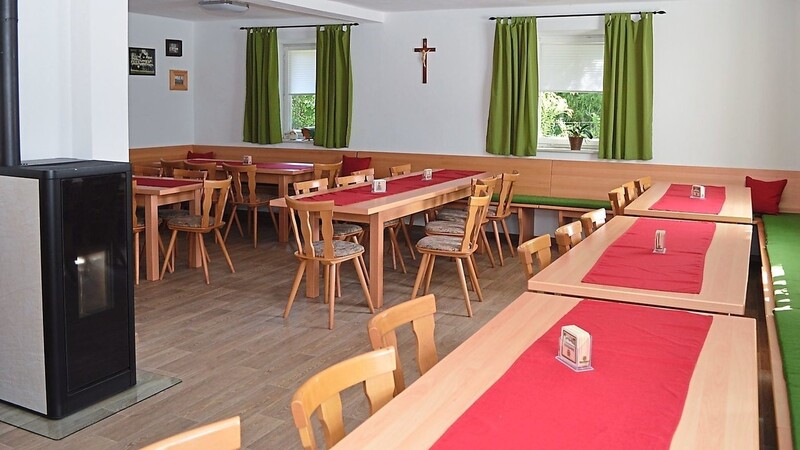 Die renovierte Gaststube mit neuem Fußboden, Tischen, Stühlen und Bänken.