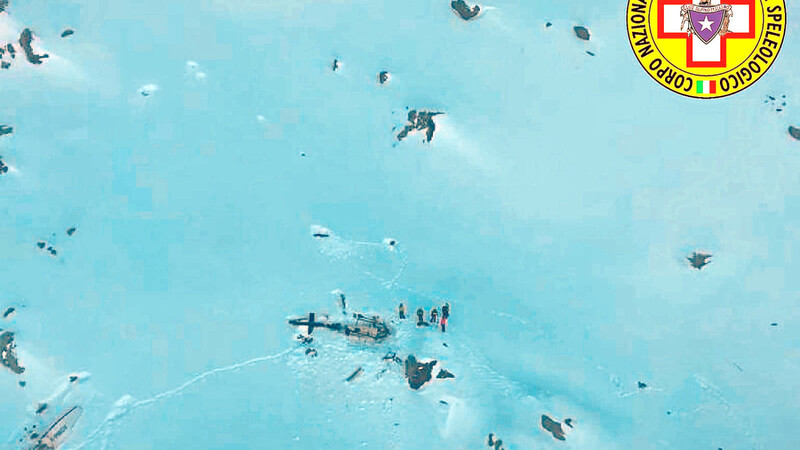 Das vom italienischen Bergrettungsdienst zur Verfügung gestellte Bild zeigt eine Gruppe von Bergrettern neben den Trümmern des Hubschraubers, in dem Max Schierer (kleines Bild) ums Leben kam.