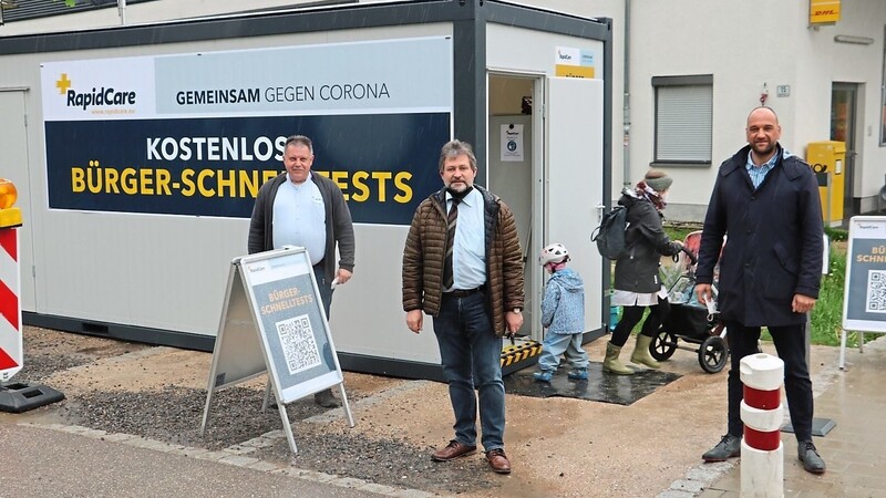 Bürgermeister Jürgen Sommer (Mitte) mit Jürgen Wittmann von Rapidcare (rechts) und Edeka-Marktleiter Rainer Lattus vor dem Container, in dem die Tests vorgenommen werden.