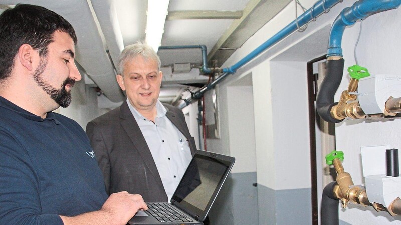 Johannes Hierold (links) liest einen Fehler aus, den der digitale Wasserzähler angezeigt hat. Der Geschäftsführer der Chamer Stadtwerke, Stefan Raab, blickt seinem Mitarbeiter über die Schulter.