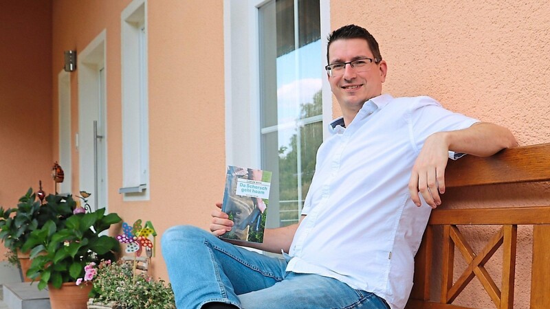 Autor Florian Bock sitzt - passend für einen Heimatkrimi - mit seinem Erstlingswerk vor seinem Haus. Daheim sei er überhaupt am liebsten. "In den Urlaub zieht's mich auch nicht oft", sagt er offen - auch wenn's den beiden Kindern und der Frau zuliebe dann doch mal soweit kommt.