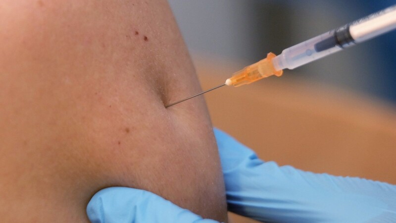 Ein Mann wird in einem Impfzentrum gegen Corona geimpft.