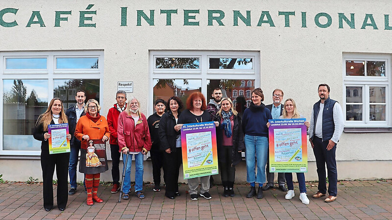 Annelies Huber (Mitte, mit Plakat) präsentiert mit einigen Vertretern der Verbände das diesjährige Plakat der Interkulturellen Wochen vor dem Café International.