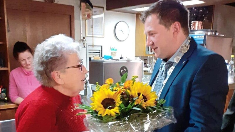 Prackenbachs Bürgermeister Andreas Eckl überreicht Zeitungsreporterin Margarete Holzfurtner Blumen und den Ehrenbrief der Gemeinde.